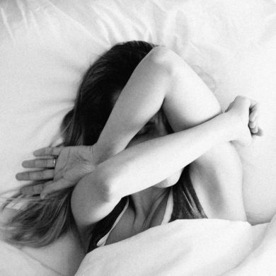 woman feeling nauseous in bed