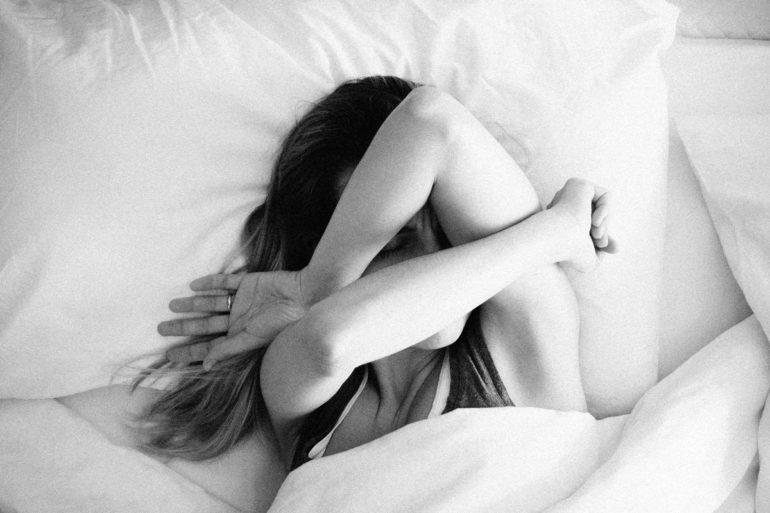woman feeling nauseous in bed